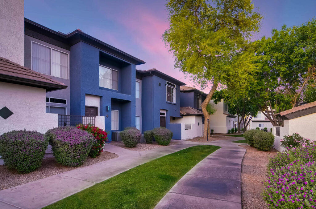 paved path between buildings, lush landscaping