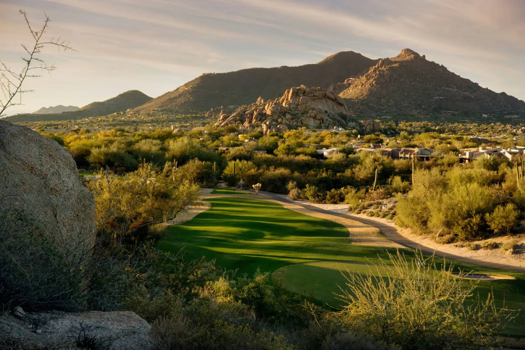 Desert scene with golf course in the fore ground and mountains on the horizon