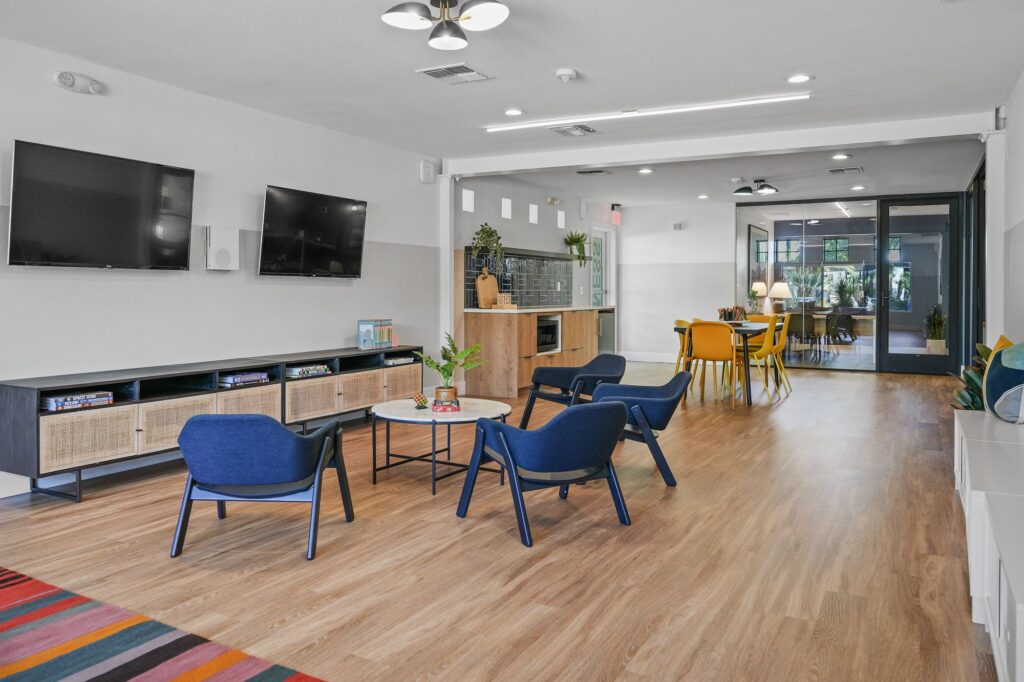 Common area with lounge seating, TVs, kitchenette, and conference room